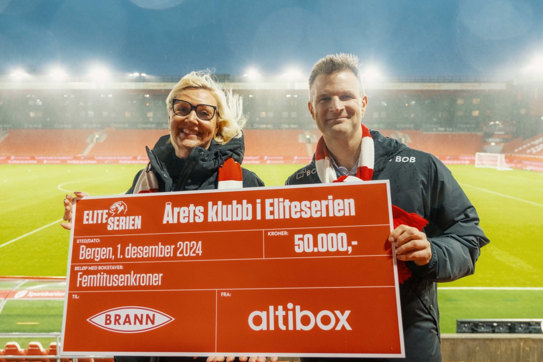 Vibecke Utengen, sponsorsjef i Altibox holder sjekken på 50 000 kr sammen med Christian Kalvenes, daglig leder i Brann.